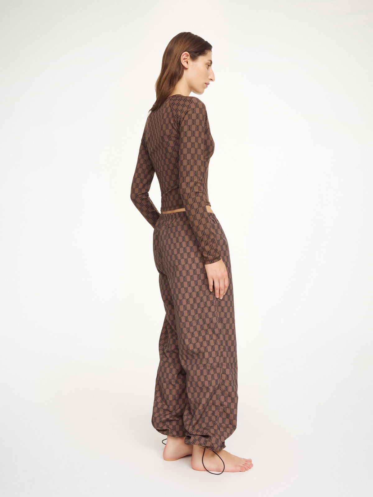 Woman wearing a brown patterned outfit on a white background
