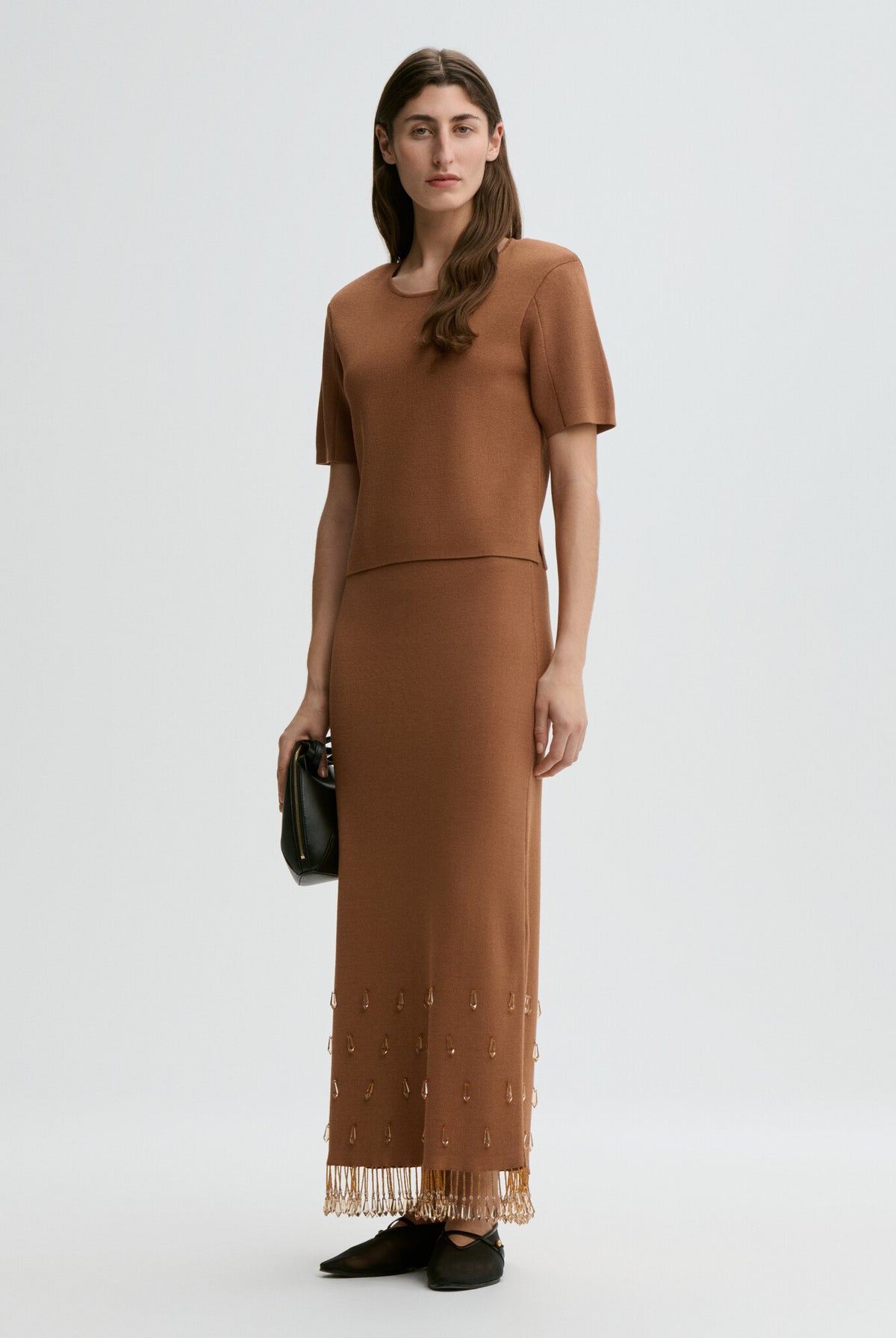 Woman wearing a brown dress with a white background