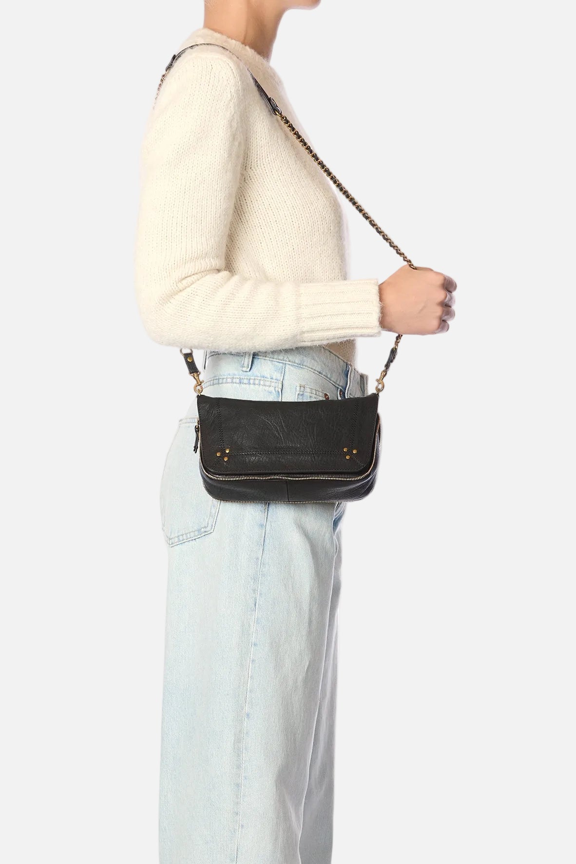 Person wearing a black crossbody bag with a white background