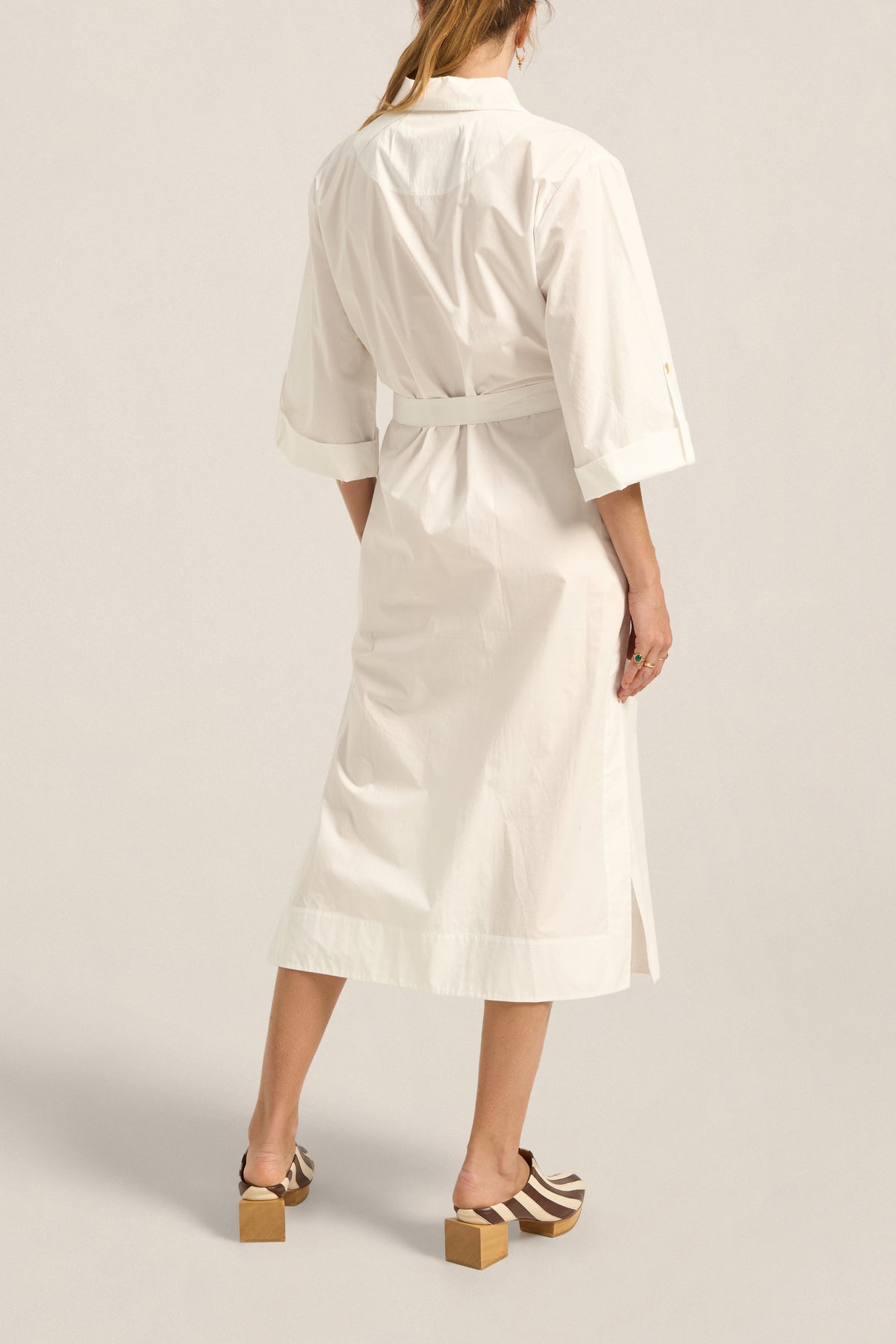Woman wearing a white robe on a plain background