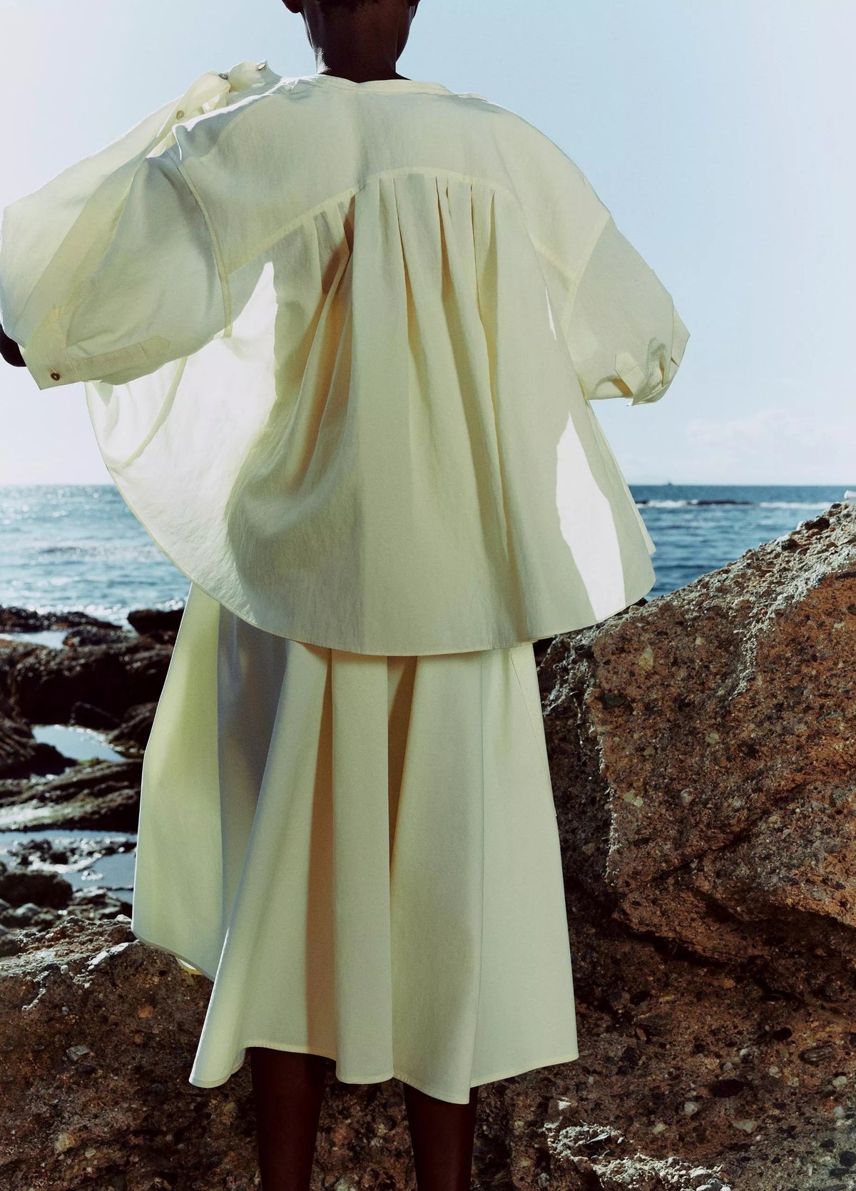 Model wears a yellow outfit by Vince