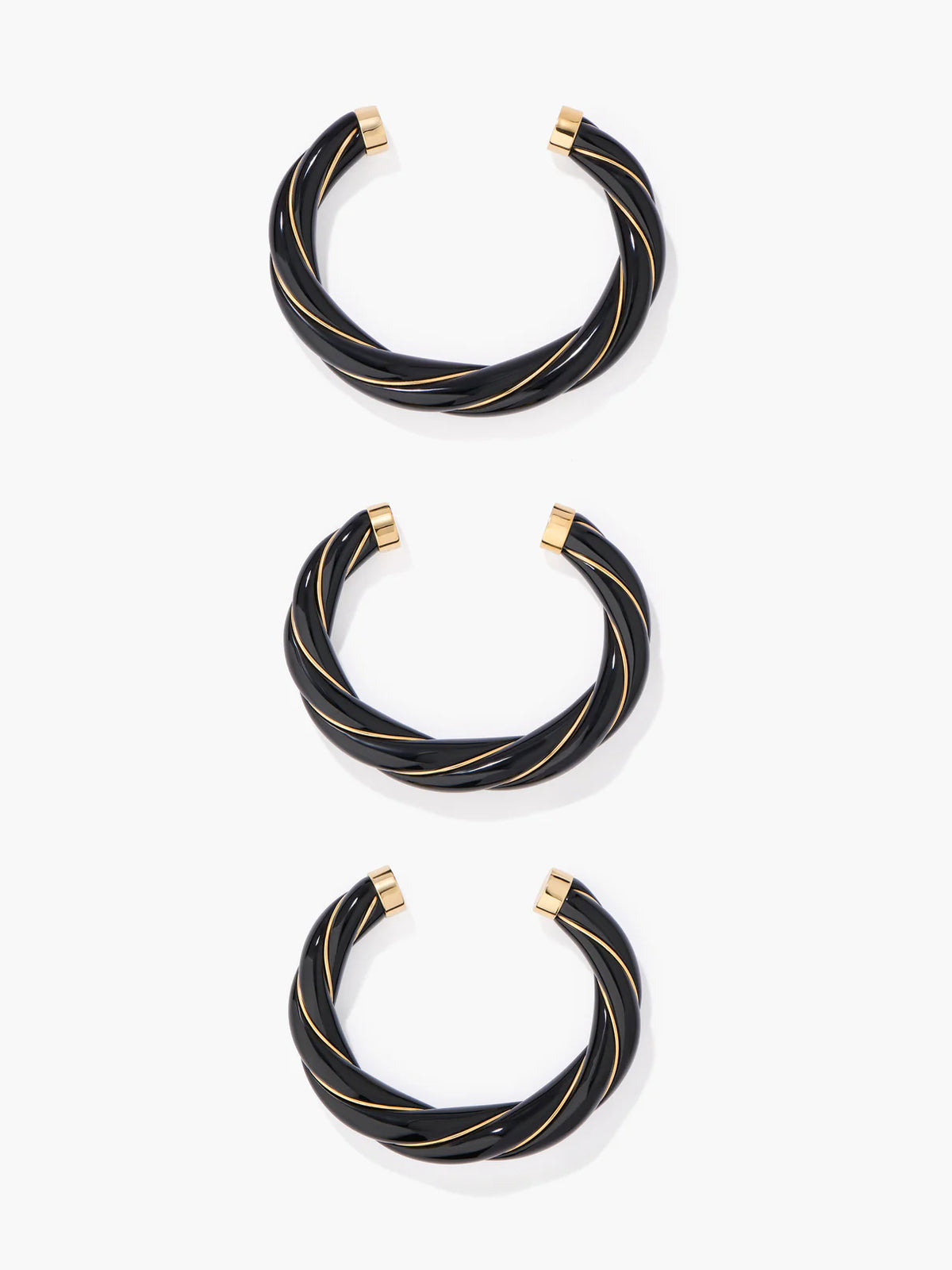 Set of black bangles with gold accents on a white background