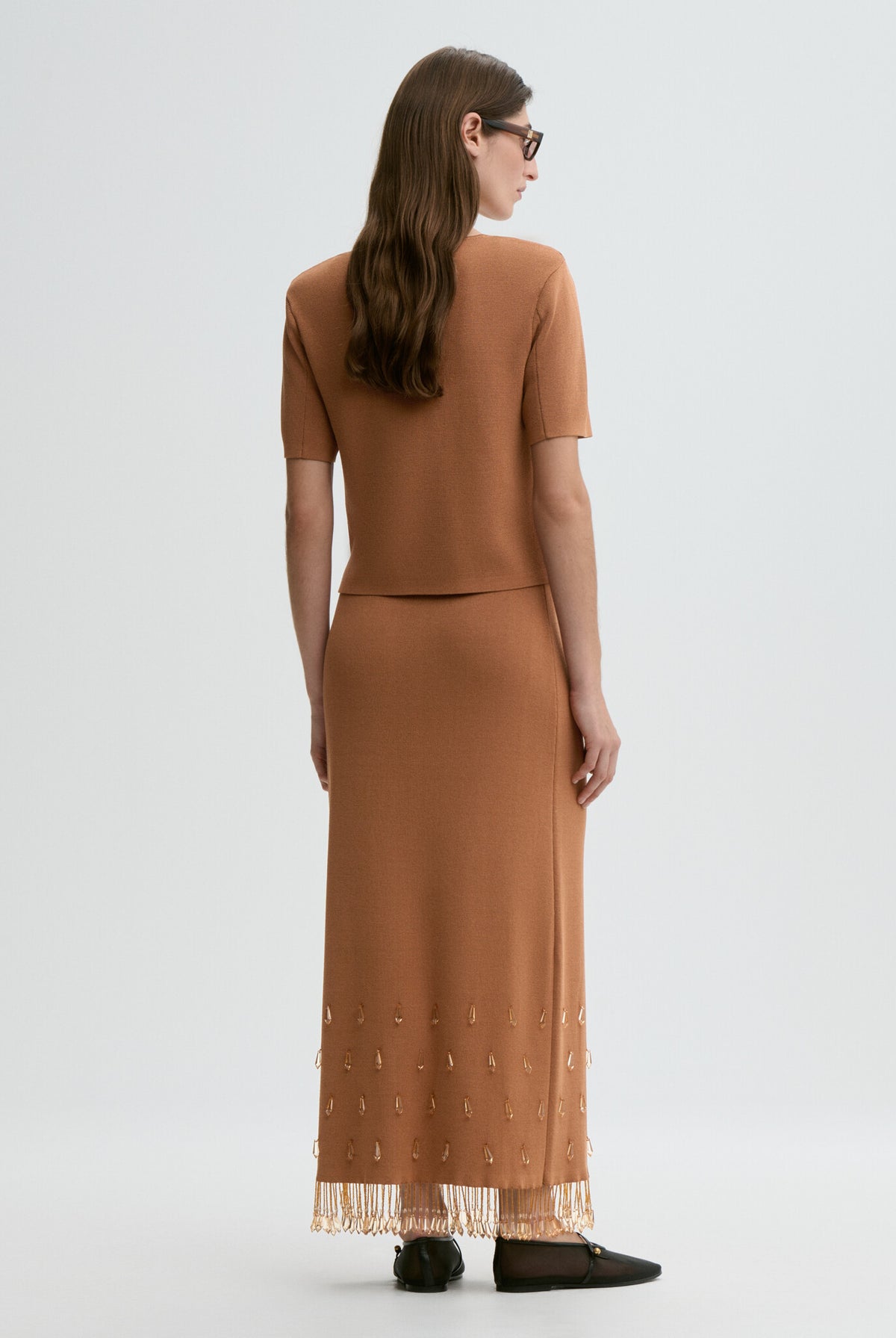 Woman wearing a brown dress with a plain white background