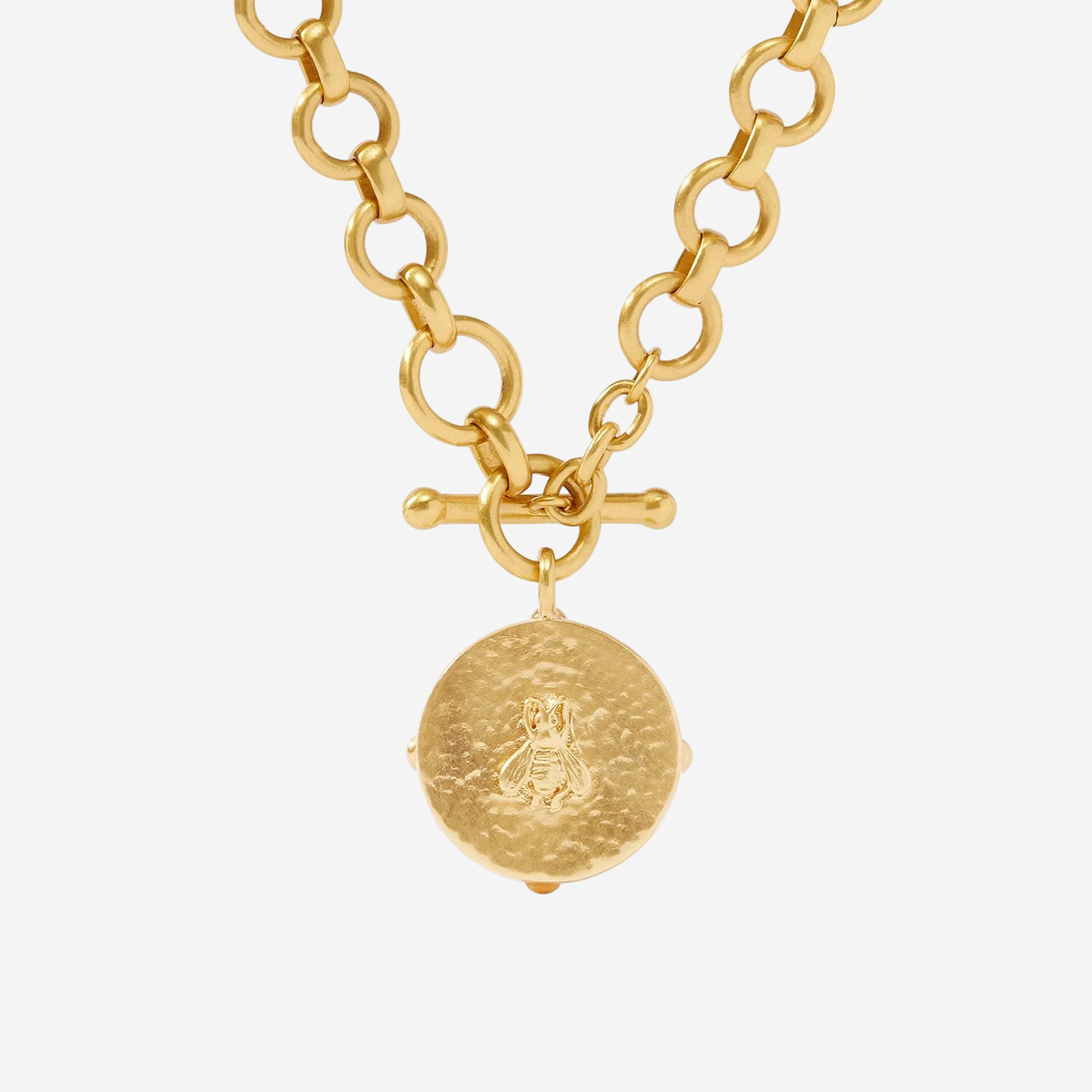 Gold necklace with a round pendant on a white background