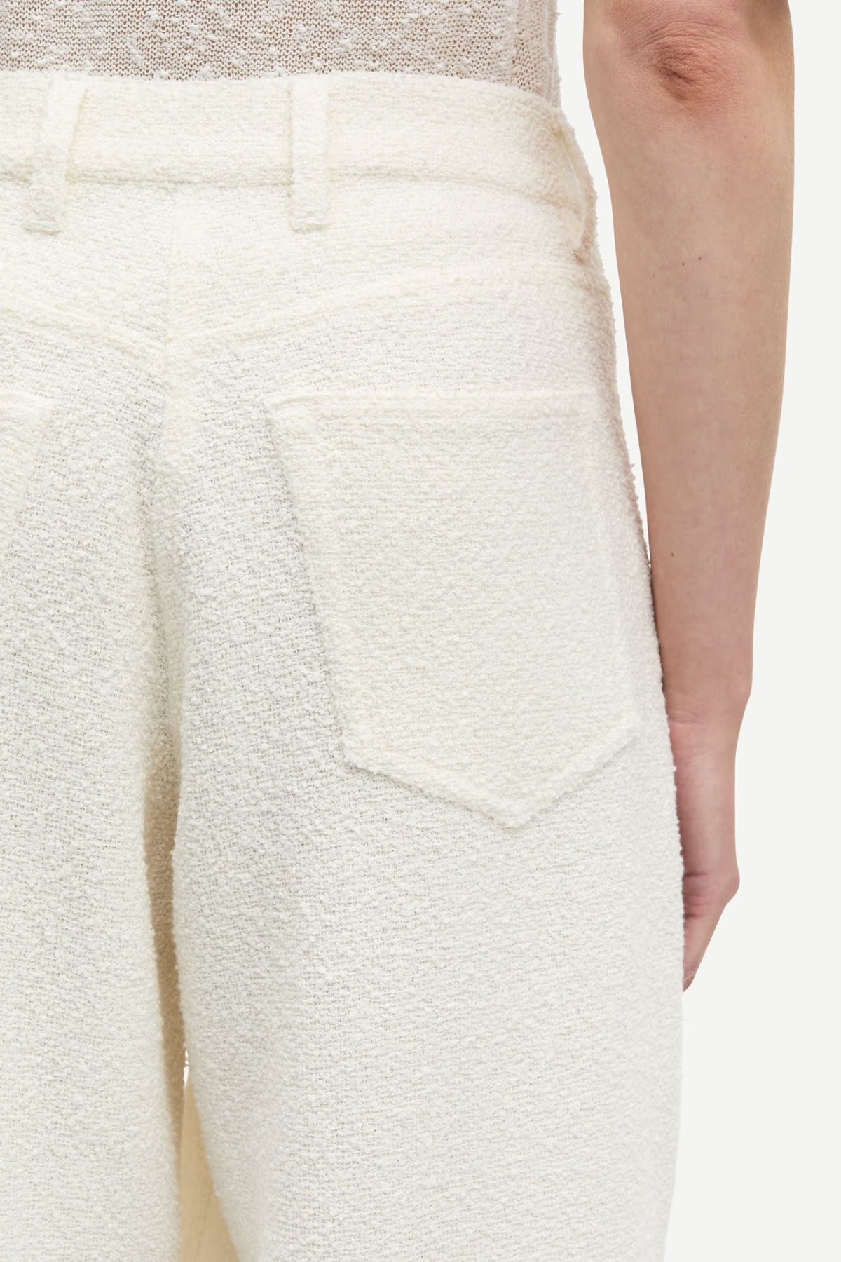 Close-up of textured white pants with a neutral background