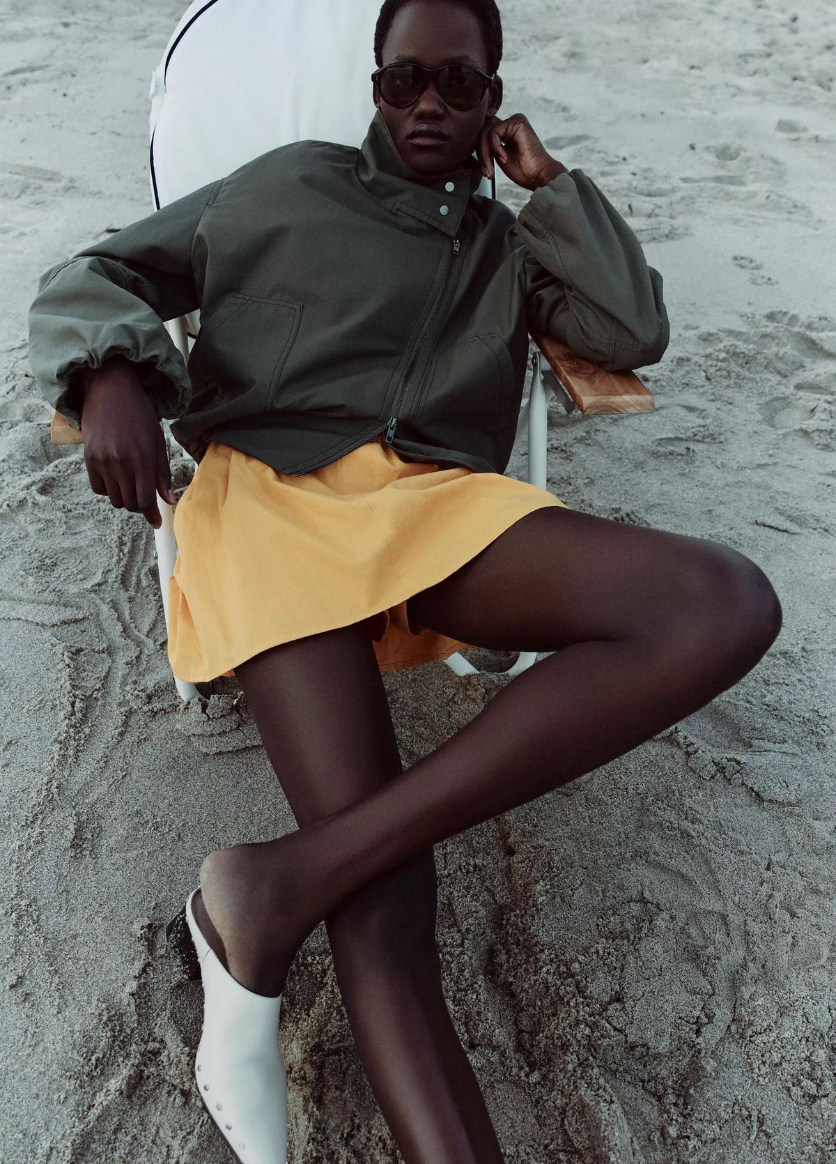 woman wears green jacket and yellow skirt