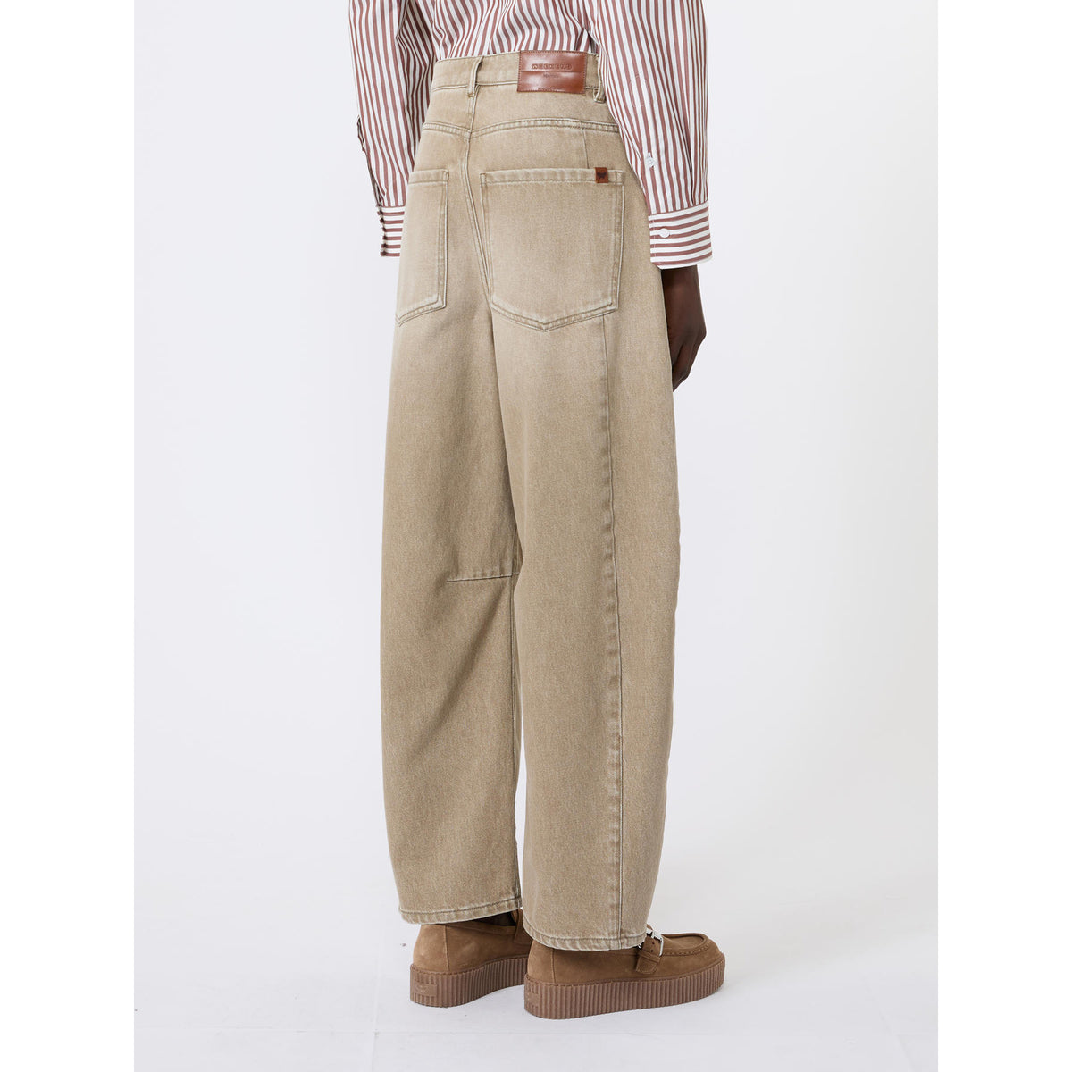 Person wearing beige wide-leg pants with a white background