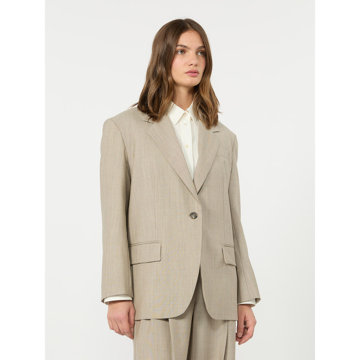 Woman wearing a beige suit on a white background
