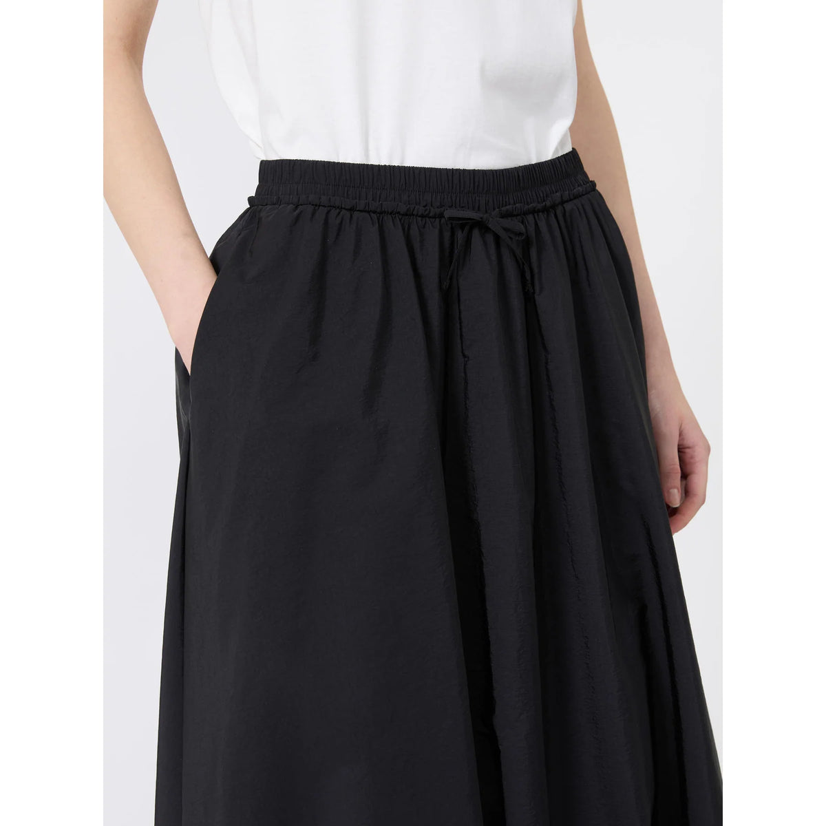 Black skirt worn by a person on a white background