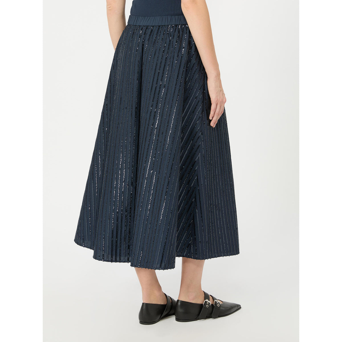 Navy pleated skirt worn by a person on a white background