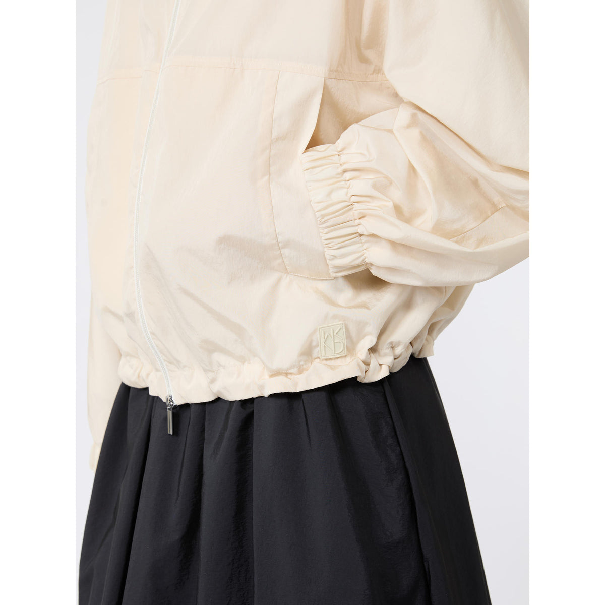 Beige jacket and black pants on a white background