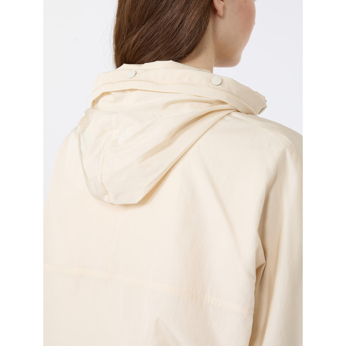 Beige raincoat worn by a person on a white background