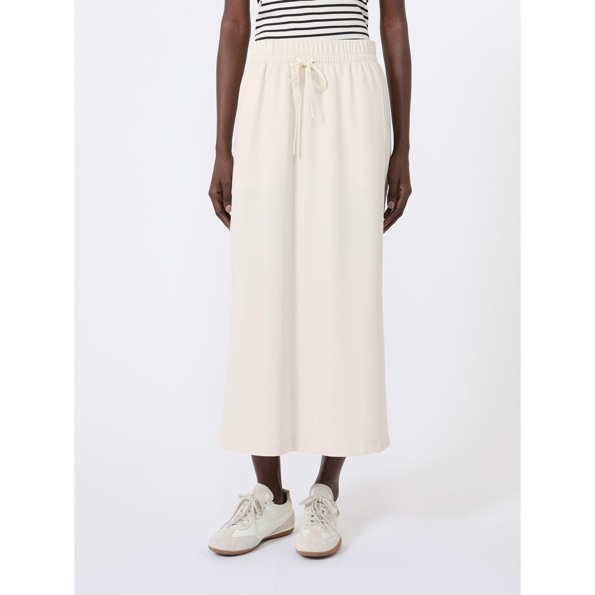 Person wearing a white skirt and striped shirt on a white background