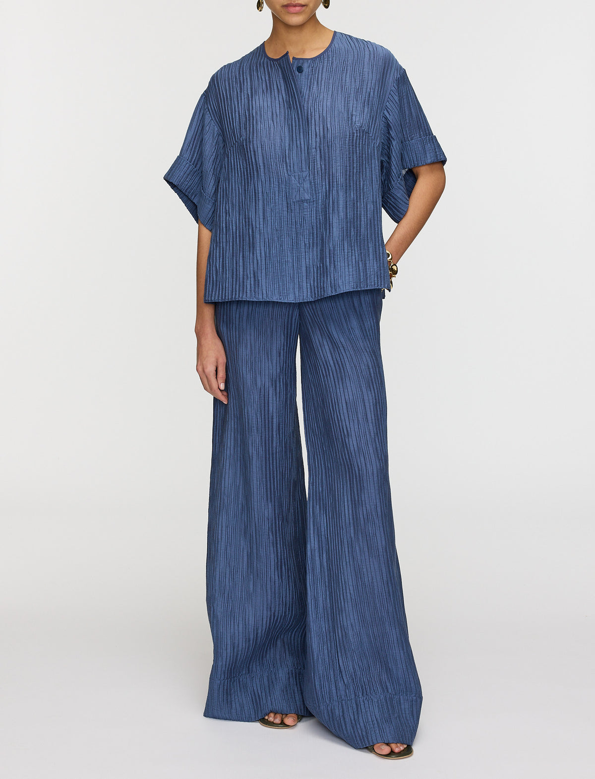 Person wearing a blue textured outfit on a white background