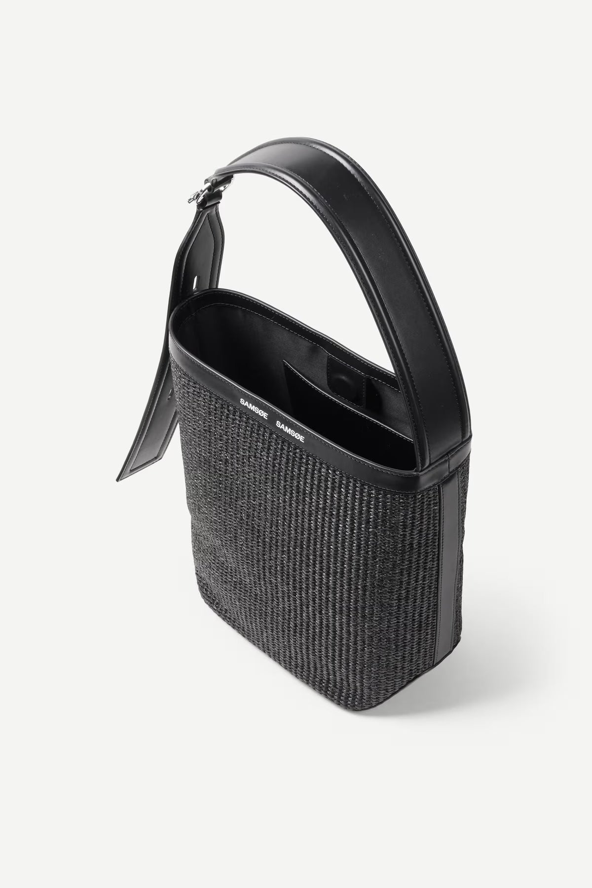 Black handbag with textured body and glossy handle on a white background