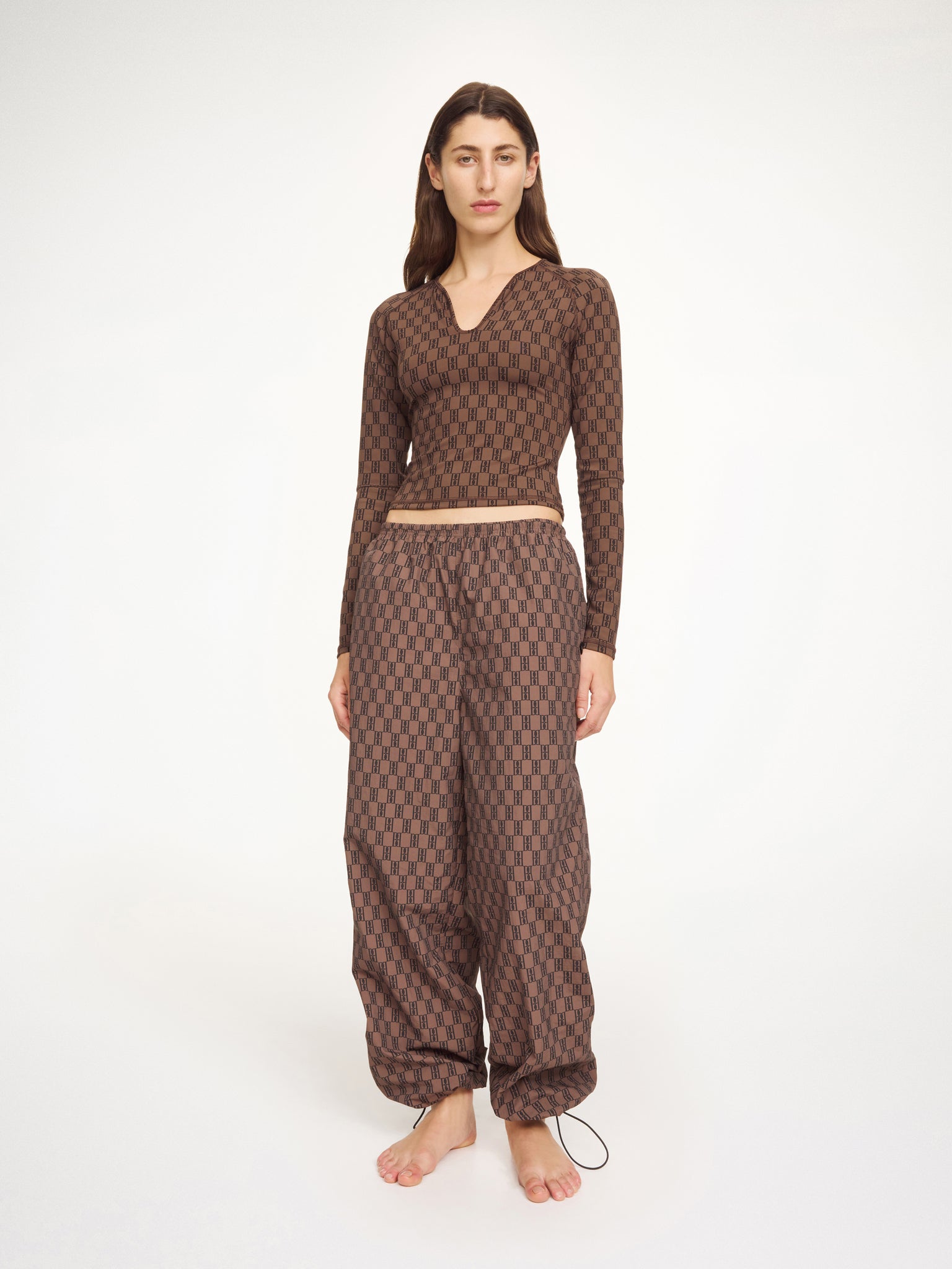 Woman wearing a brown patterned outfit on a white background