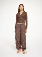 Woman wearing a brown patterned outfit on a white background
