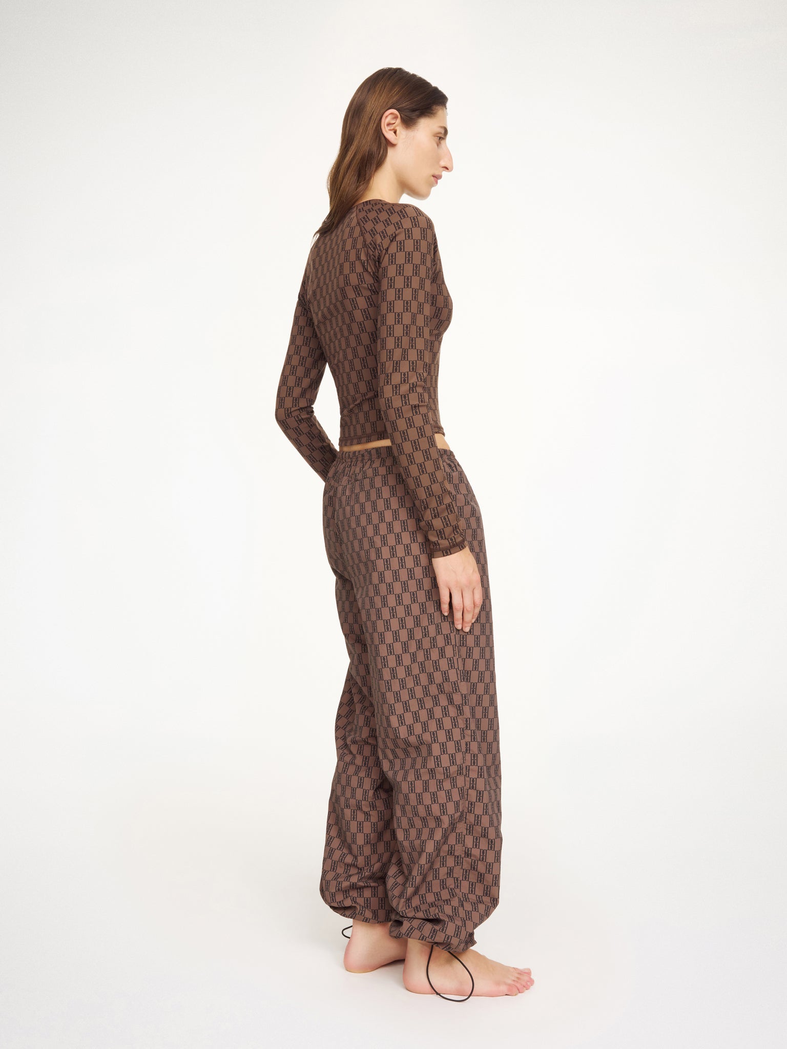 Woman wearing a brown patterned outfit on a white background