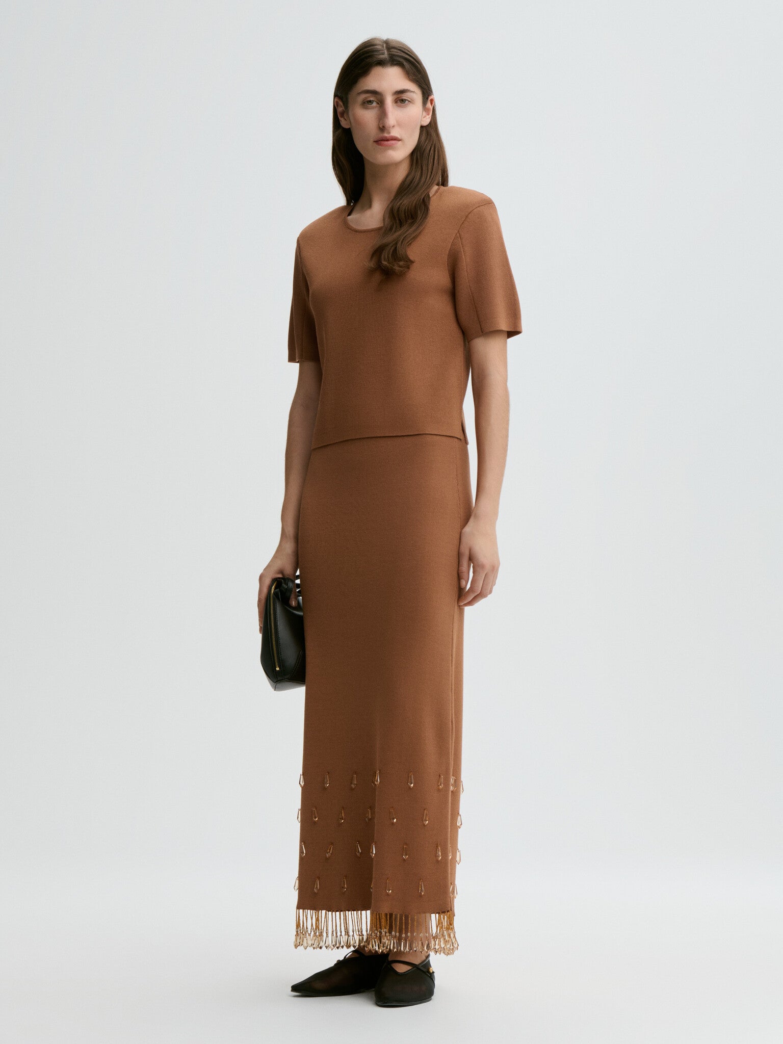 Woman wearing a brown dress with a white background