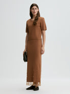 Woman wearing a brown dress with a white background