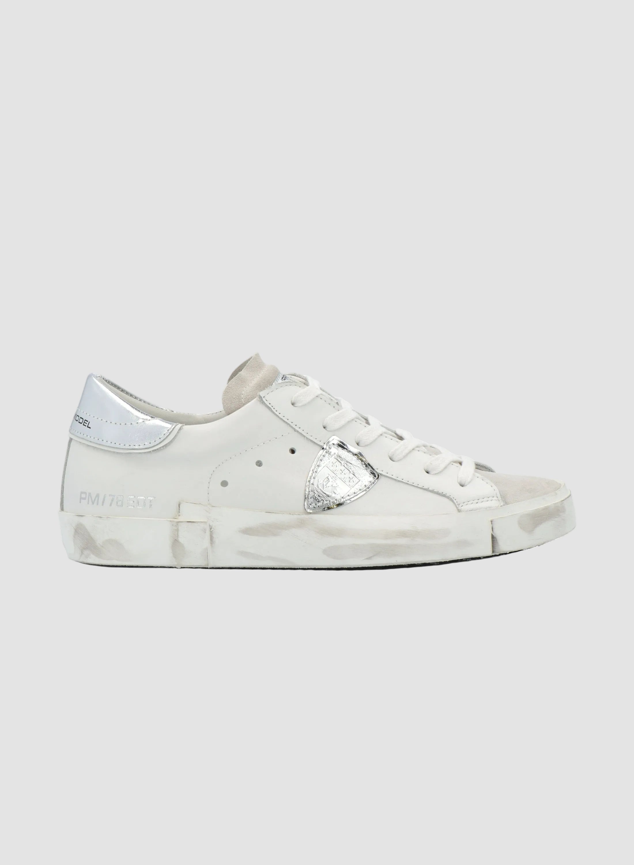White sneaker with silver accents on a white background