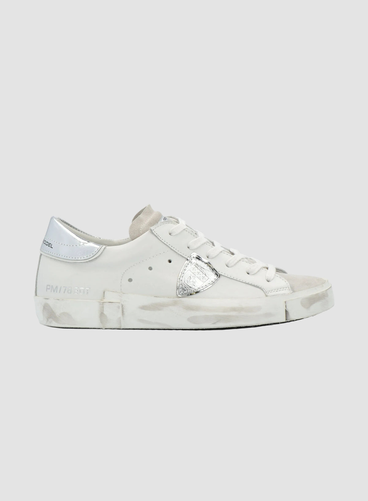 White sneaker with silver accents on a white background