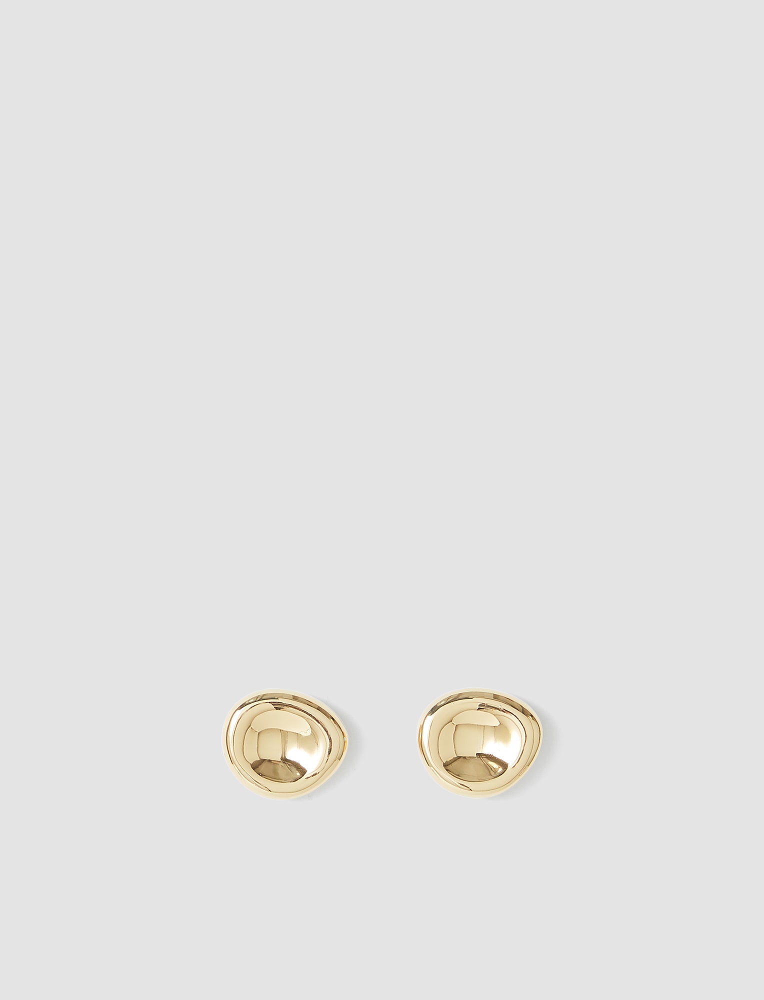 Pair of gold earrings on a light gray background