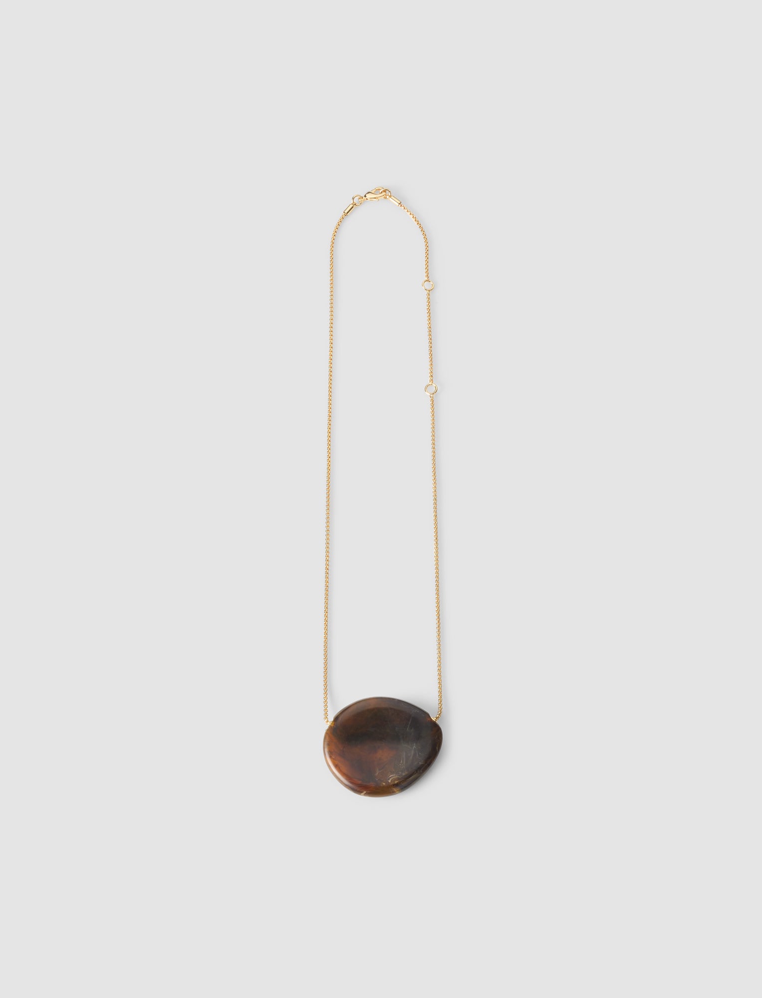 Necklace with a dark brown pendant on a light gray background