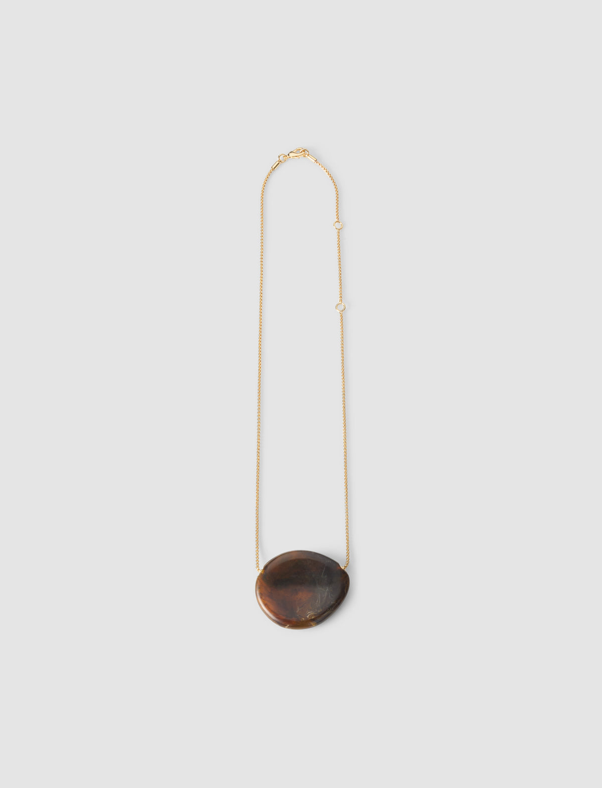 Necklace with a dark brown pendant on a light gray background