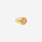 Gold signet ring on a white background