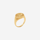 Gold ring with a bee emblem on a white background