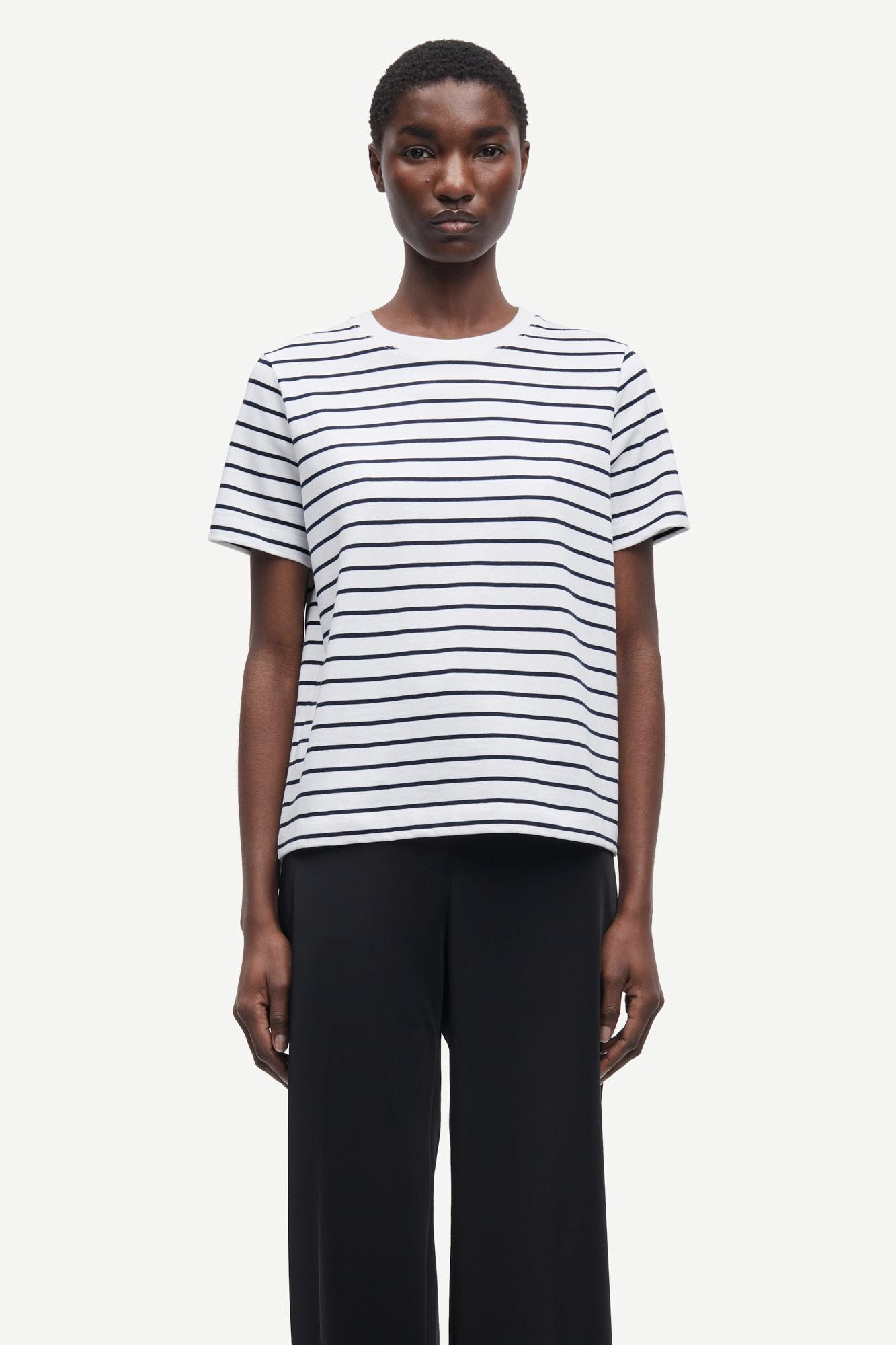 Person wearing a black and white striped t-shirt on a plain background