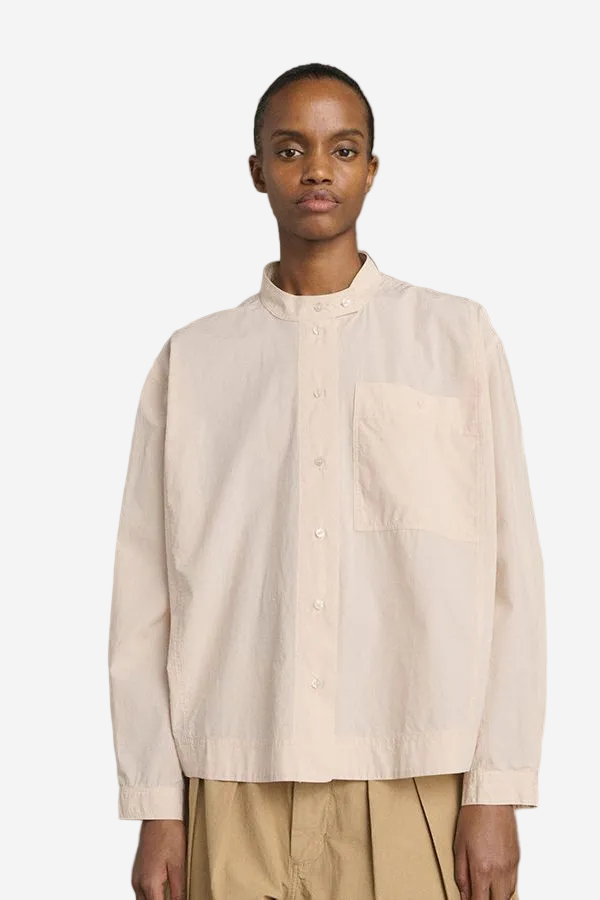Person wearing a beige shirt against a gray background