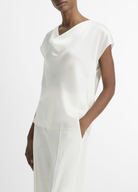 Woman wearing a white outfit on a plain background