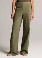 Person wearing olive green wide-leg pants on a plain background