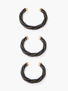 Set of black bangles with gold accents on a white background