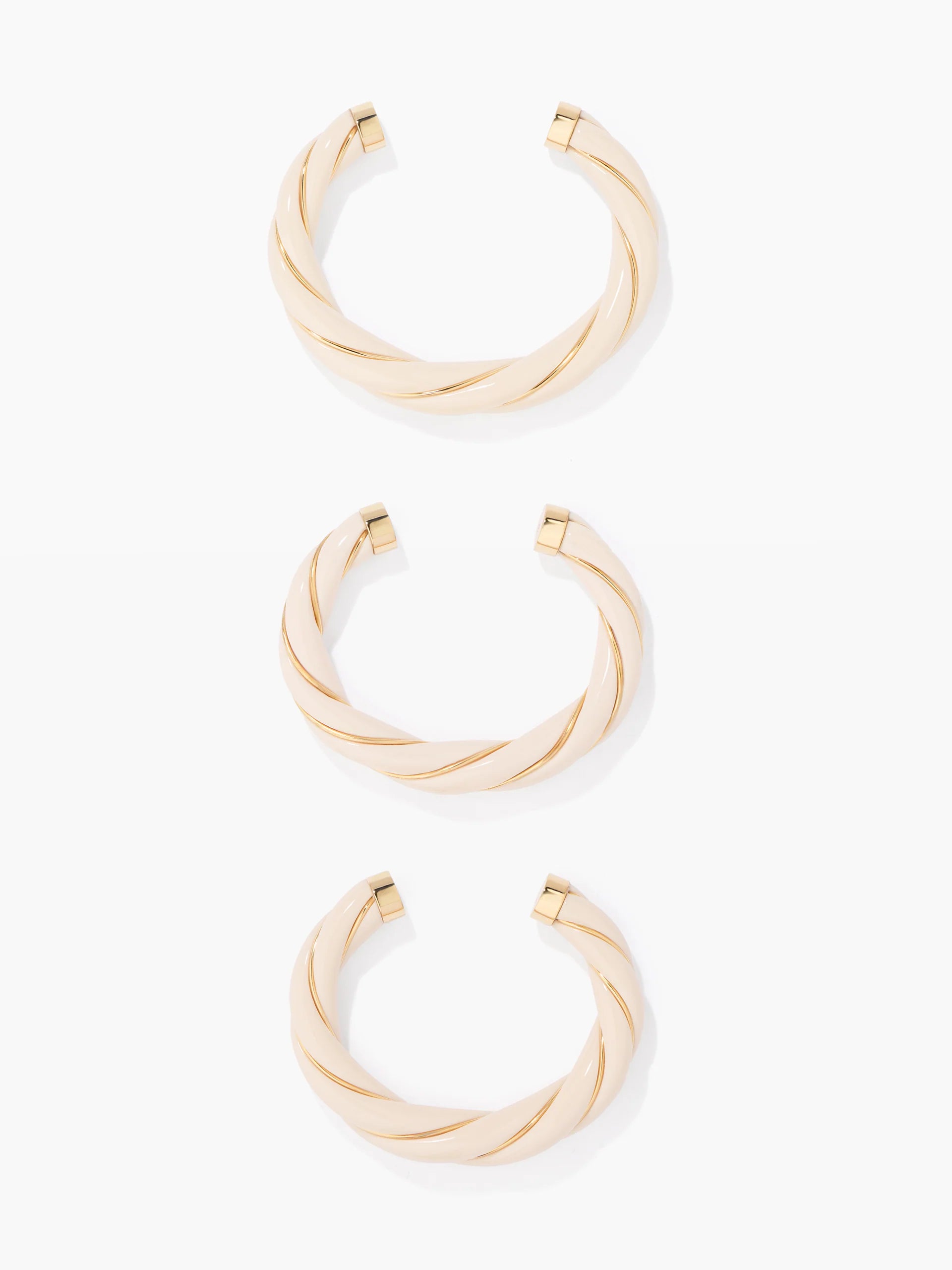 Three gold bangles on a white background