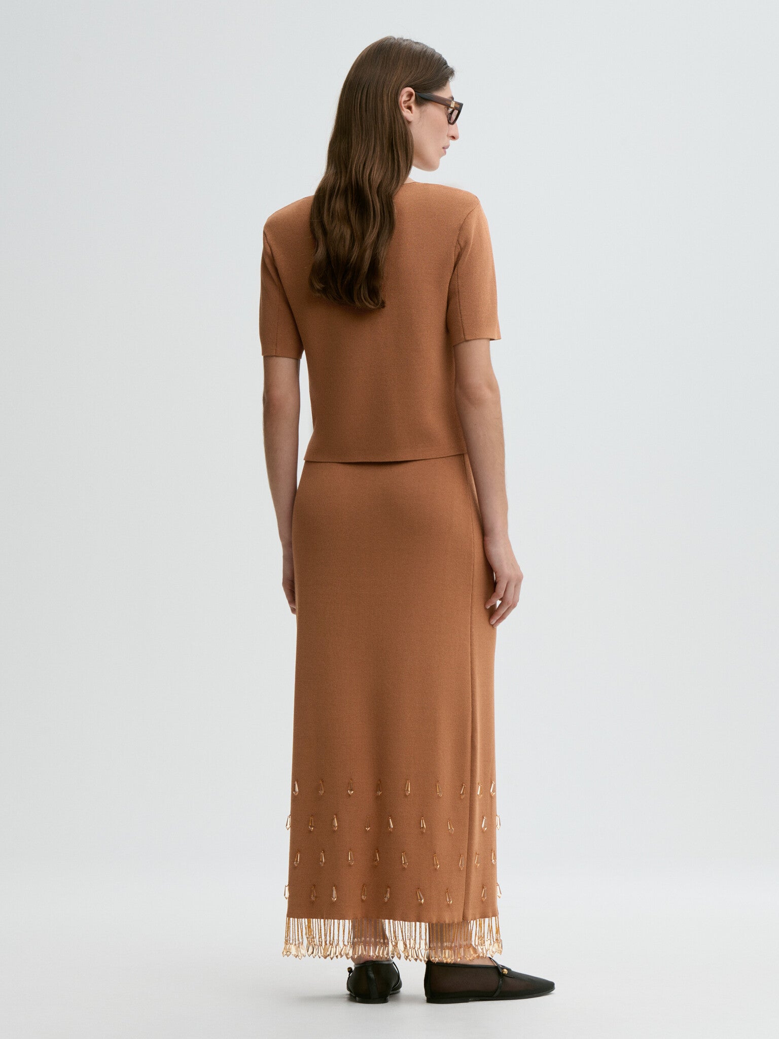 Woman wearing a brown dress with a plain white background