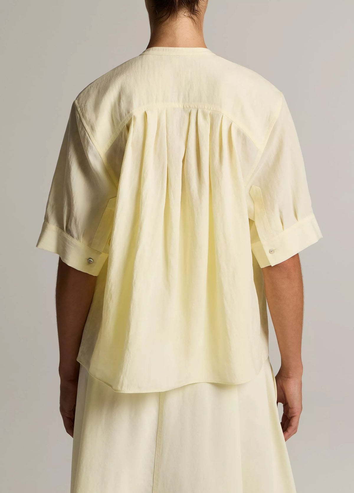 Model wears yellow shirt