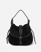 Black suede handbag with leather accents on a light gray background