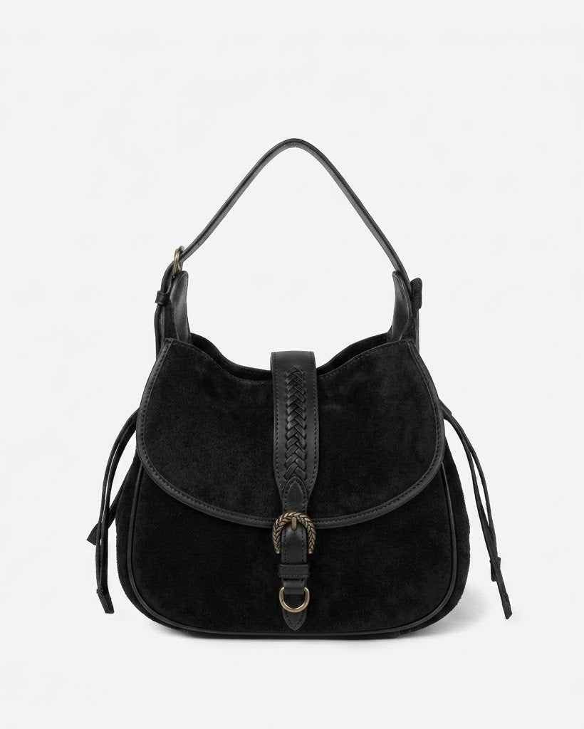 Black suede handbag with leather accents on a light gray background