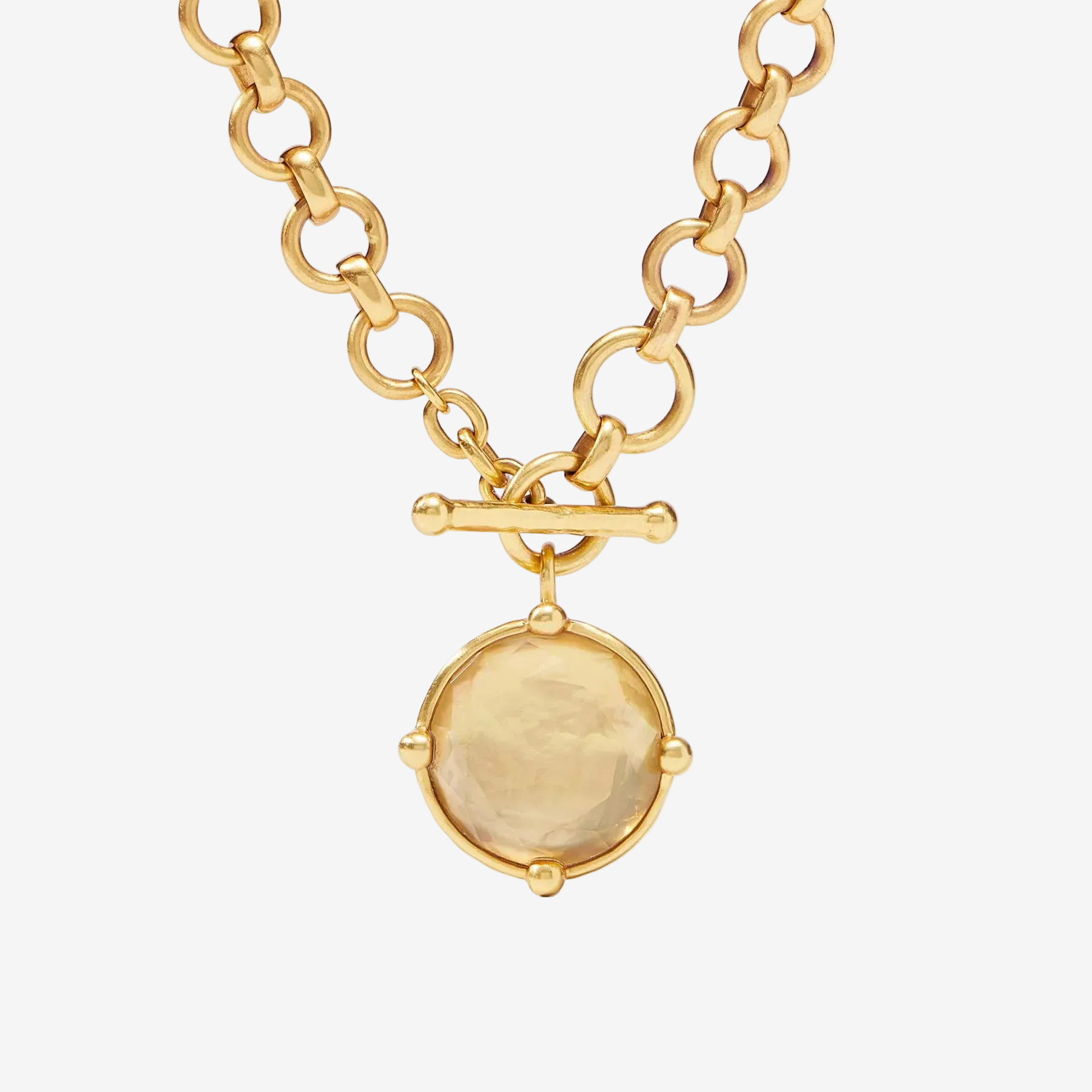 Gold necklace with a round pendant on a white background