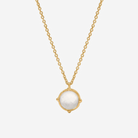 Gold necklace with a white pendant on a white background