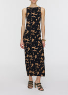Woman wearing a sleeveless dress with a pattern on a white background