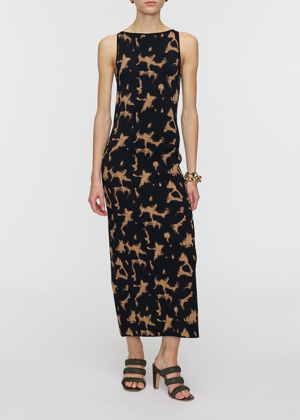 Woman wearing a sleeveless dress with a pattern on a white background