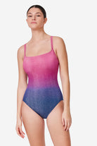 Woman wearing a pink and blue gradient swimsuit on a white background