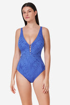 Woman wearing a blue leaf-patterned swimsuit on a white background