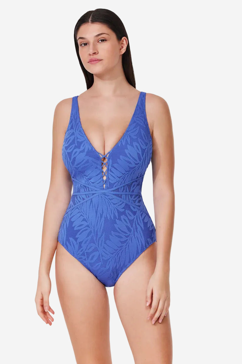 Woman wearing a blue leaf-patterned swimsuit on a white background
