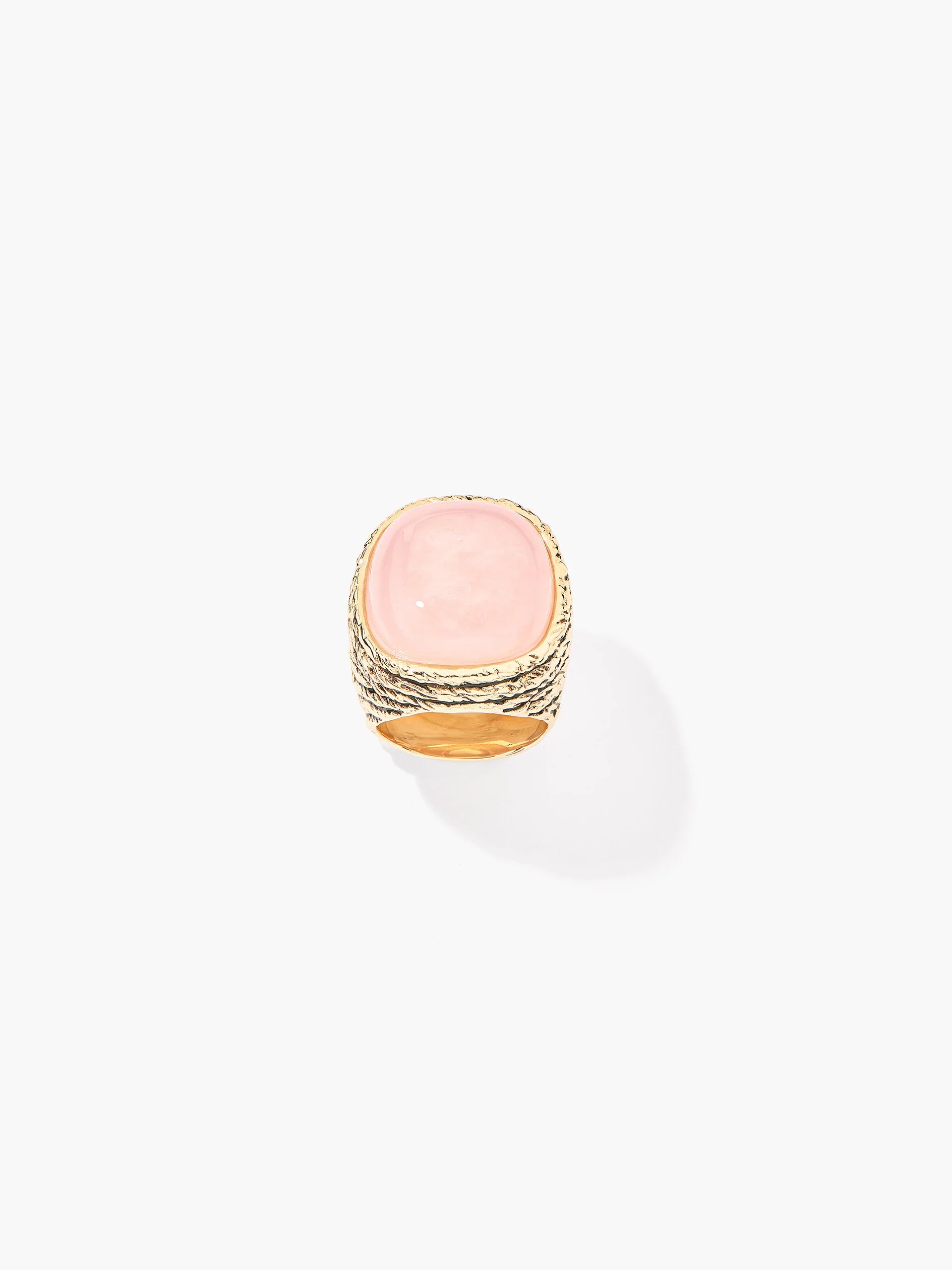 Ring with pink stone and gold band on a white background