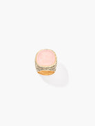 Ring with pink stone and gold band on a white background